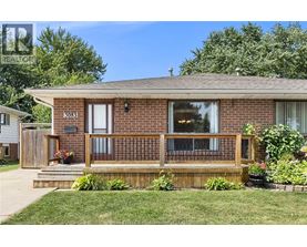 A house with a brown brick exterior and a wooden deck.