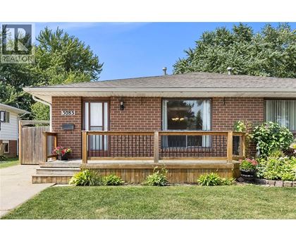 A house with a brown brick exterior and a wooden deck.