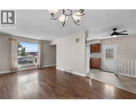 A spacious living room with hardwood floors and a ceiling fan.