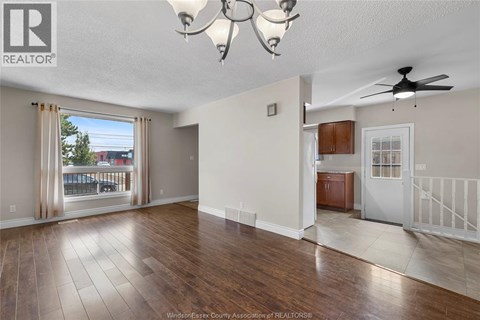 A spacious living room with hardwood floors and a ceiling fan.