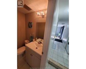 A bathroom with a toilet, sink, and mirror.
