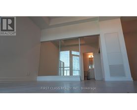 A real estate company's logo is displayed on a wall in an empty room.