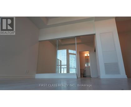 A real estate company's logo is displayed on a wall in an empty room.