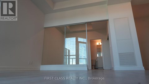 A real estate company's logo is displayed on a wall in an empty room.