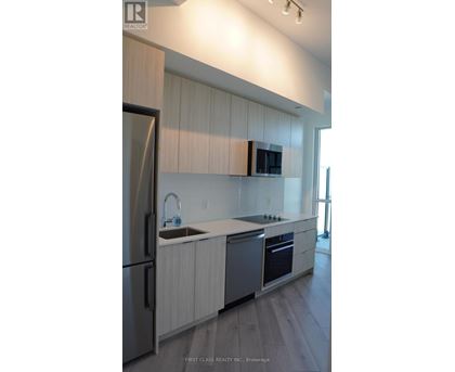 A modern kitchen with a refrigerator, sink, and oven.