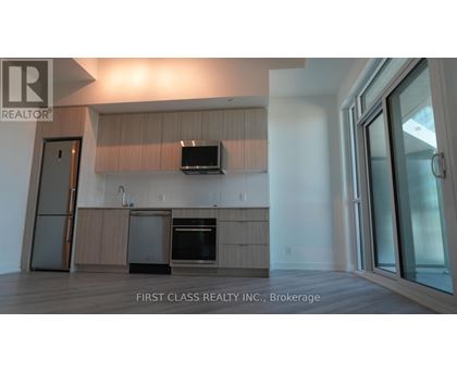 A modern kitchen with wooden cabinets and a flat screen TV mounted above the island.