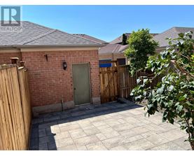 A backyard with a brick building, a wooden fence, and a green door.