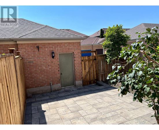 A backyard with a brick building, a wooden fence, and a green door.