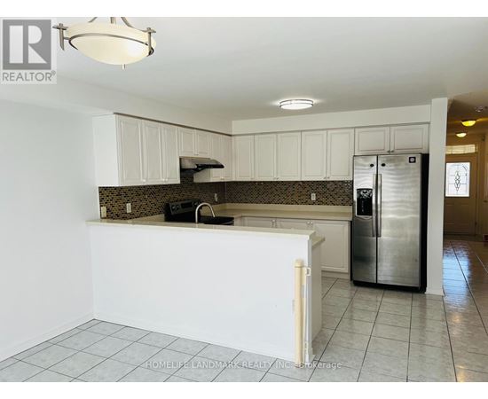 A kitchen with white cabinets and a tile floor.