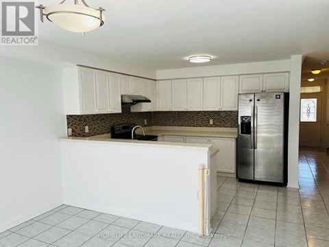 A kitchen with white cabinets and a tile floor.