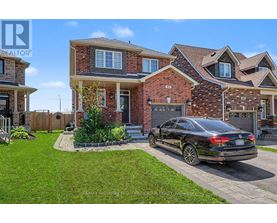 A black car is parked in front of a brick house.