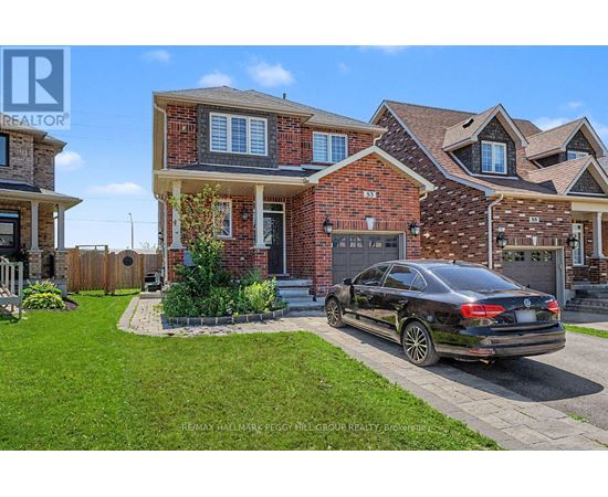 A black car is parked in front of a brick house.