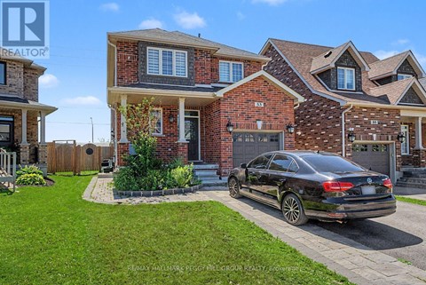 A black car is parked in front of a brick house.