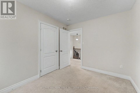 A white door is in a room with a carpet floor.