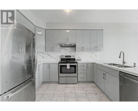 A kitchen with a refrigerator, oven, and sink.