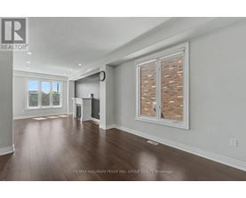 A large, empty room with a window and a clock on the wall.