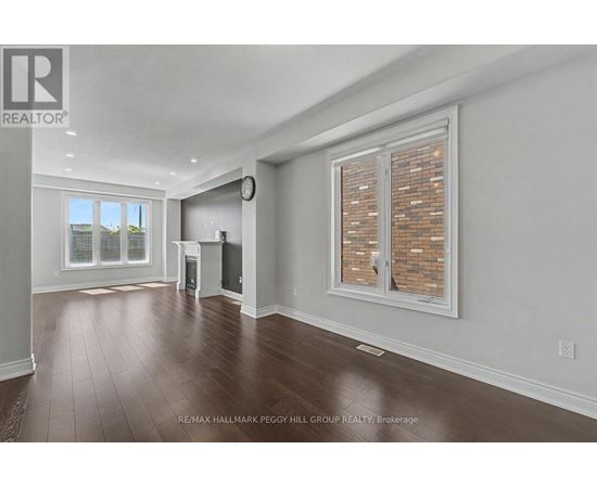 A large, empty room with a window and a clock on the wall.