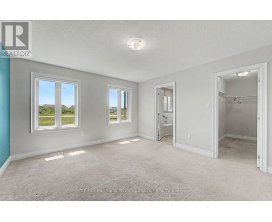 A spacious room with a view of the outdoors through the windows.