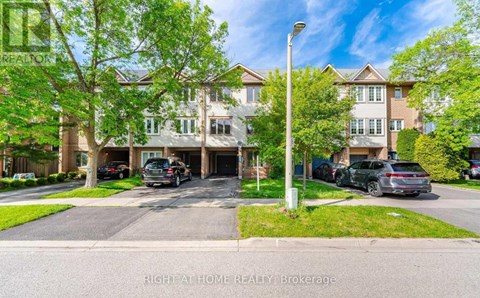 A residential area with houses and cars parked on the street.