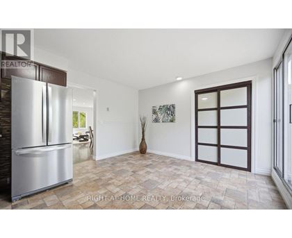 A spacious room with a tiled floor and a large refrigerator.