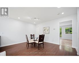 A dining room with a table and chairs.