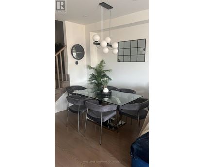 A modern dining room with a glass table and grey chairs.