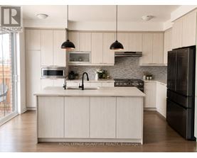 A modern kitchen with a large island and stainless steel appliances.