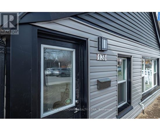A grey building with a Realtor sign on the front.