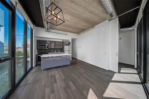 A modern kitchen with a large island and a view of the city.