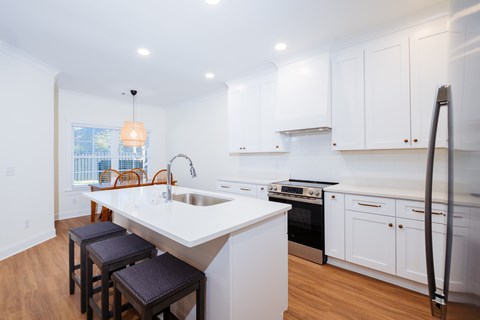 A kitchen with white cabinets and a large island.