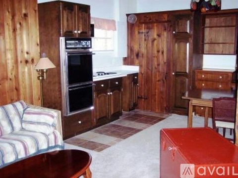 A kitchen with wooden cabinets and a striped couch.
