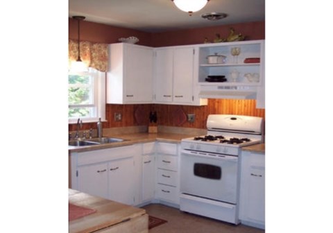 A kitchen with white cabinets and appliances.