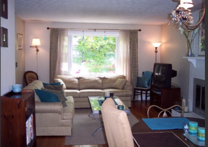 A living room with a couch, chair, and television.
