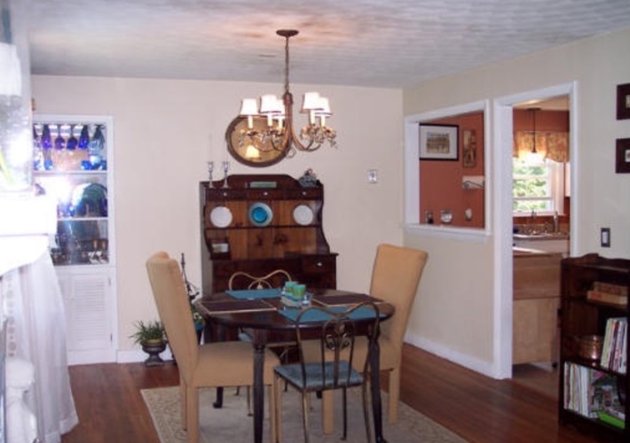 A dining room with a wooden table and chairs.
