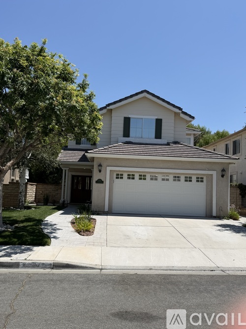 A two-story house with a white garage door is for sale.