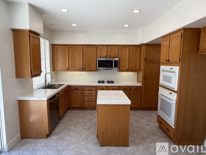 A kitchen with wooden cabinets and appliances.