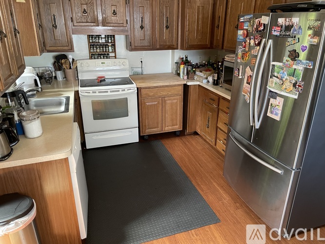 A kitchen with a refrigerator covered in magnets and a sink with a dishwasher.