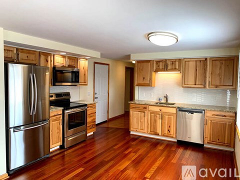 A kitchen with wooden cabinets and a refrigerator.