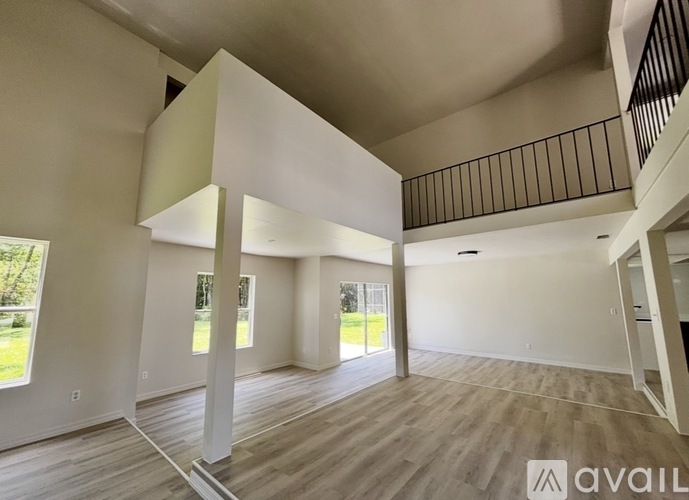 A spacious living room with a balcony and hardwood floors.