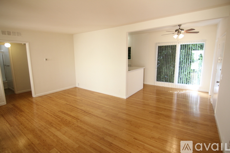 A room with wooden flooring and a ceiling fan.
