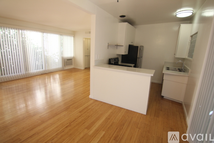 A kitchen with white cabinets and a wooden floor.