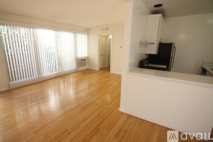 A spacious room with wooden floors and white walls.