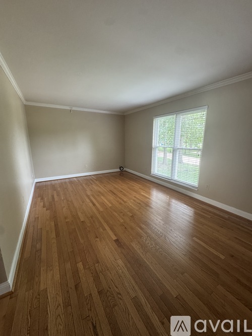 A room with wooden flooring and a window.