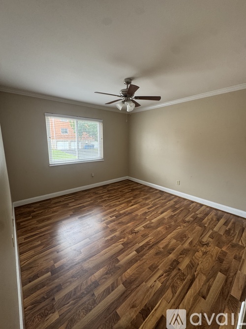 A room with wooden flooring and a ceiling fan.