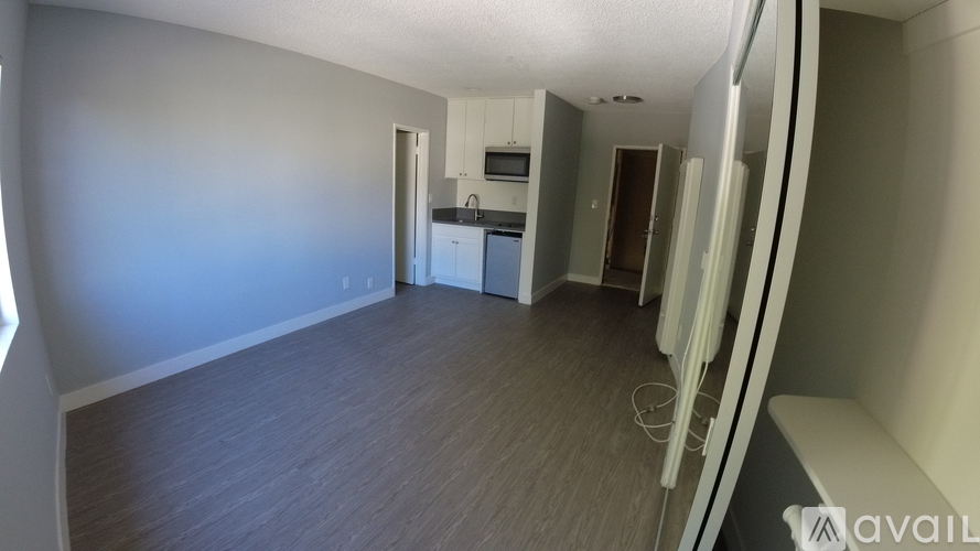 A room with a wooden floor and a wall with a window.