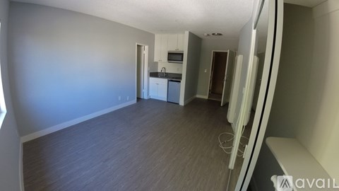 A room with a wooden floor and a wall with a window.