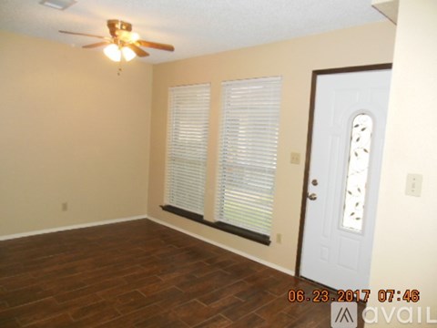 A room with a ceiling fan and a door with a window above it.
