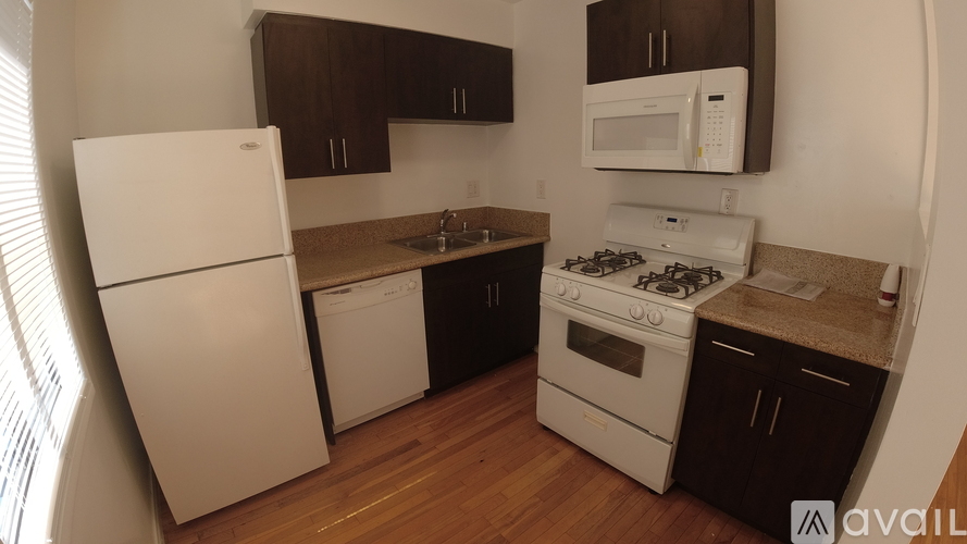 A kitchen with a white refrigerator, a white stove, and brown cabinets.