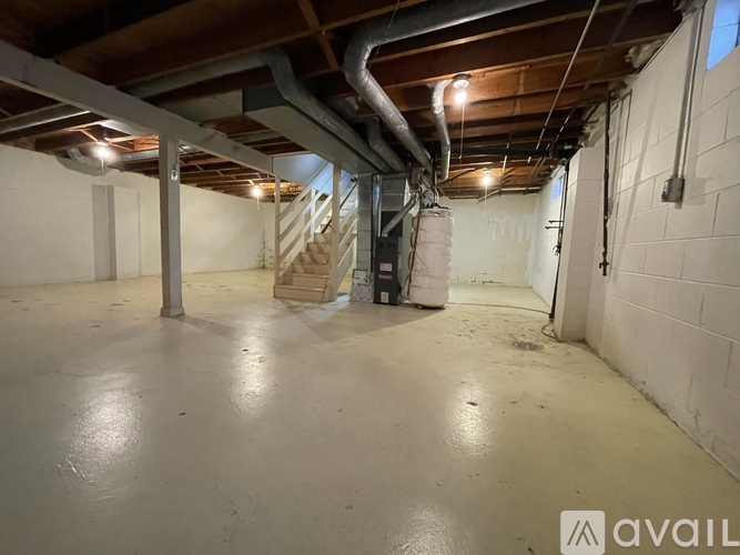 A spacious basement with a concrete floor and exposed ductwork.