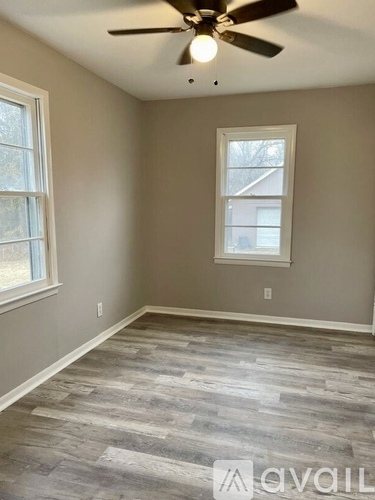 A room with a ceiling fan and a window.